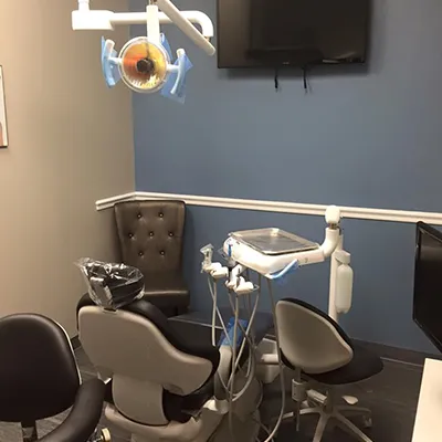 Modern dental treatment room with overhead light, patient chair, and professional equipment at Gulfside Dental.